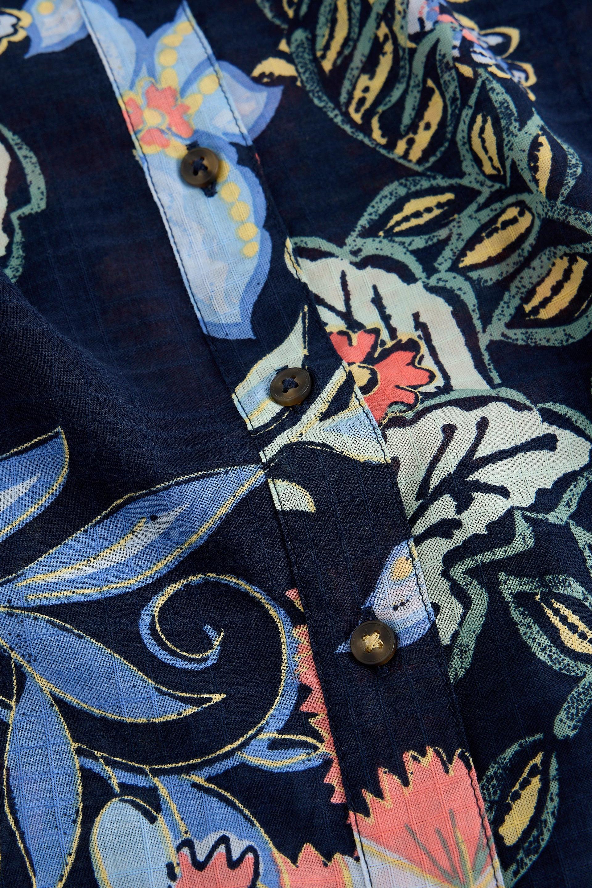 Close-up of a colorful organic cotton shirt with floral and abstract patterns.