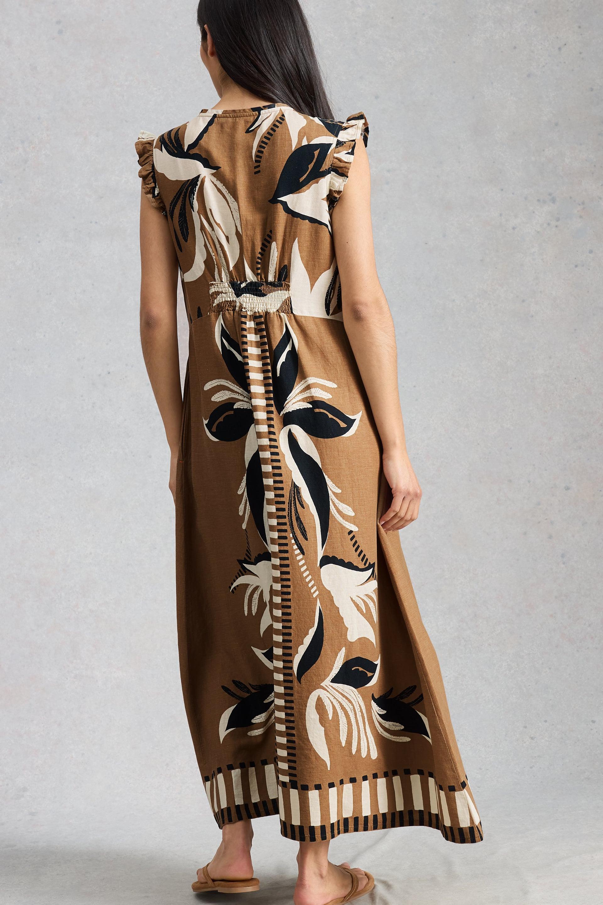Woman wearing a long, patterned linen dress with a neutral background