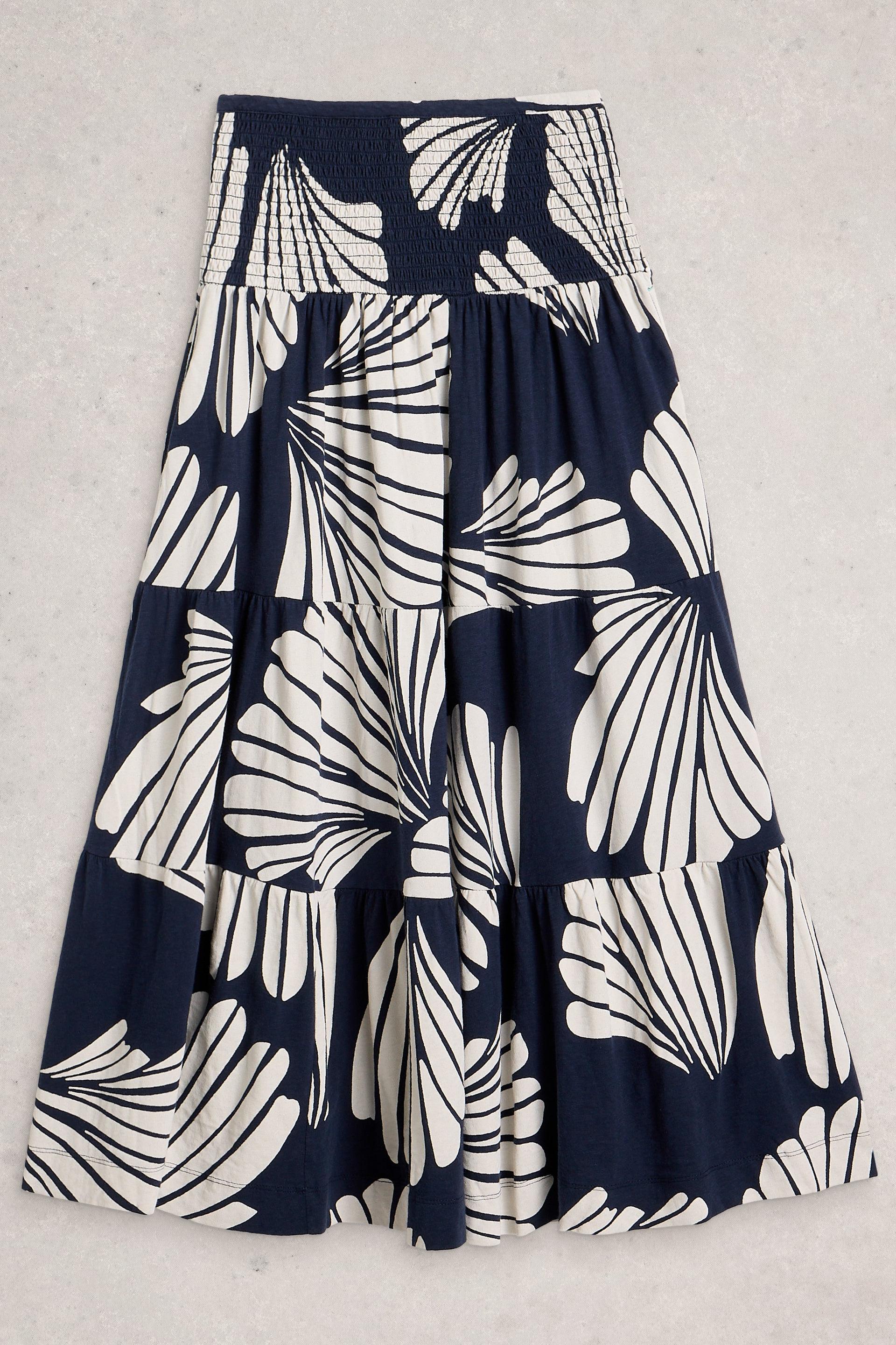 Navy blue tiered skirt with white abstract pattern on a light gray background