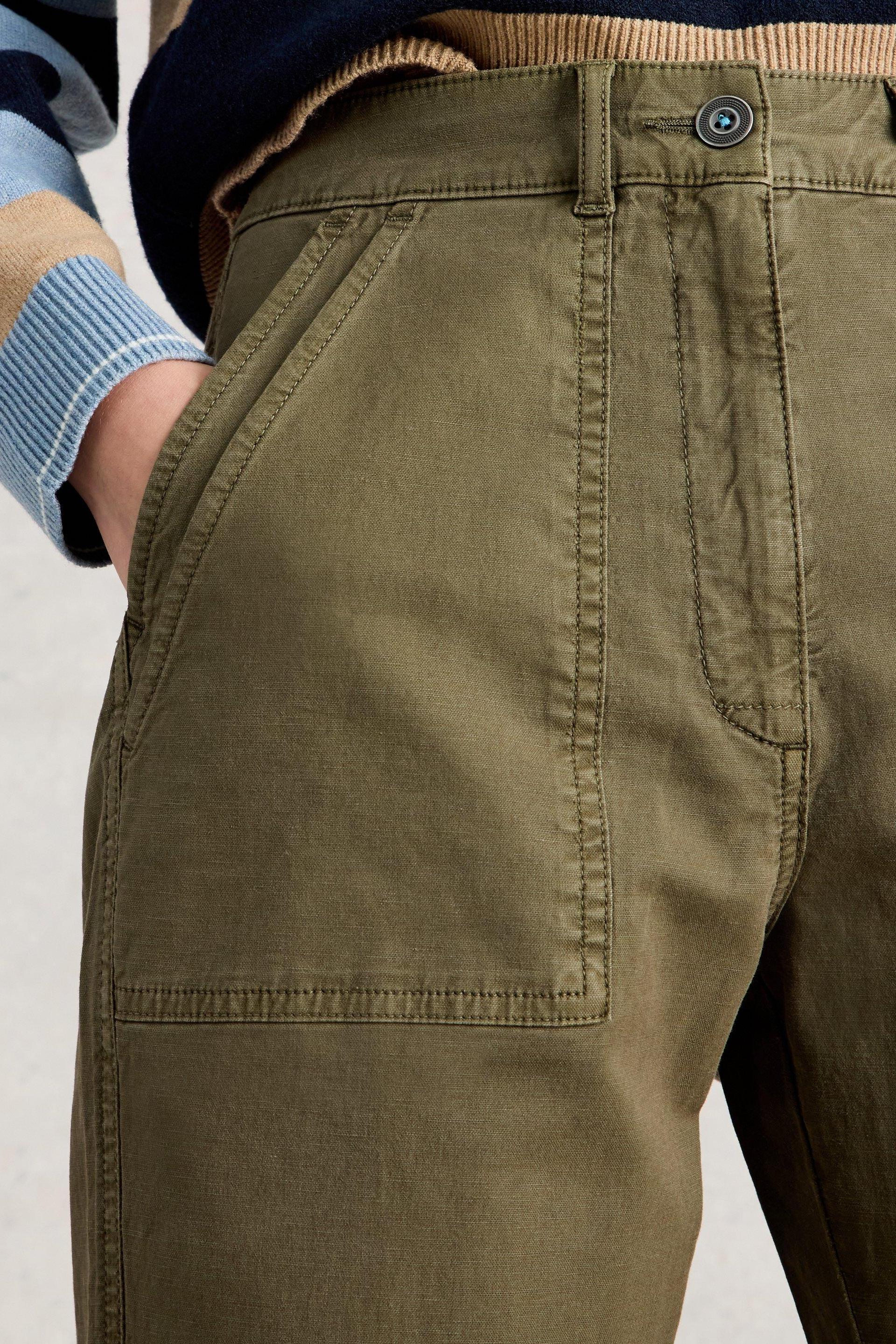 Close-up of olive green White Stuff Twister chino trousers with patch pockets and button detail.