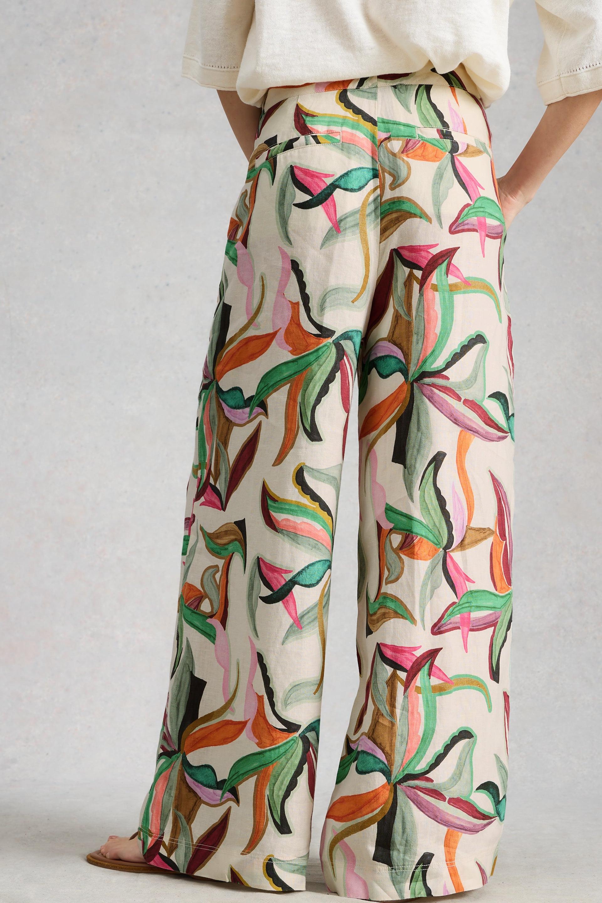 Colorful patterned pants worn by a person on a plain background