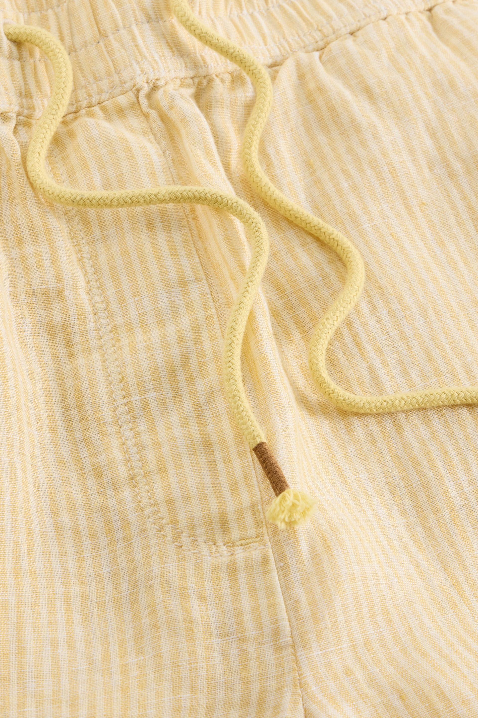 Close-up of yellow striped shorts with a drawstring