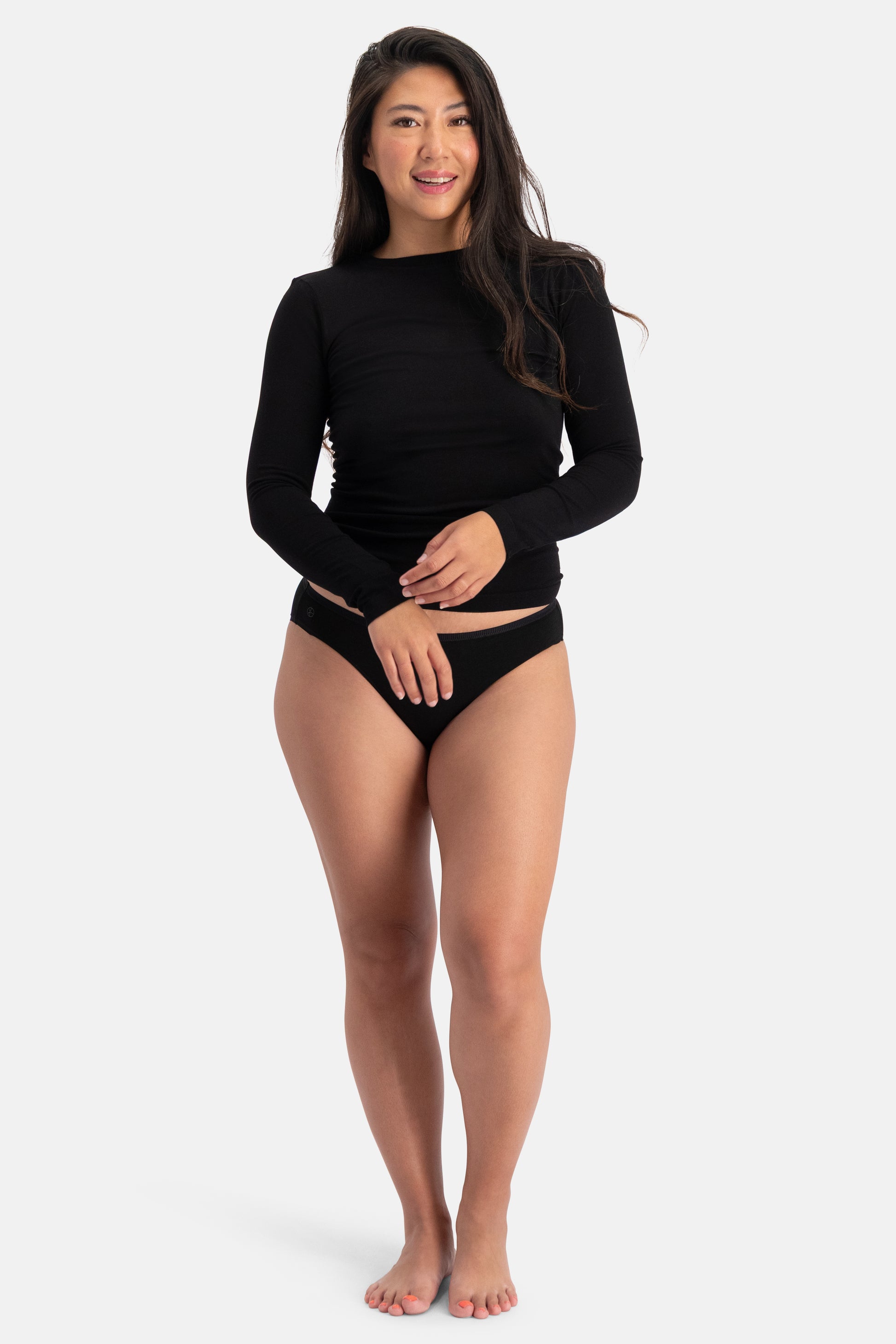 Woman wearing a black long-sleeved bamboo fabric top and matching bikini underwear