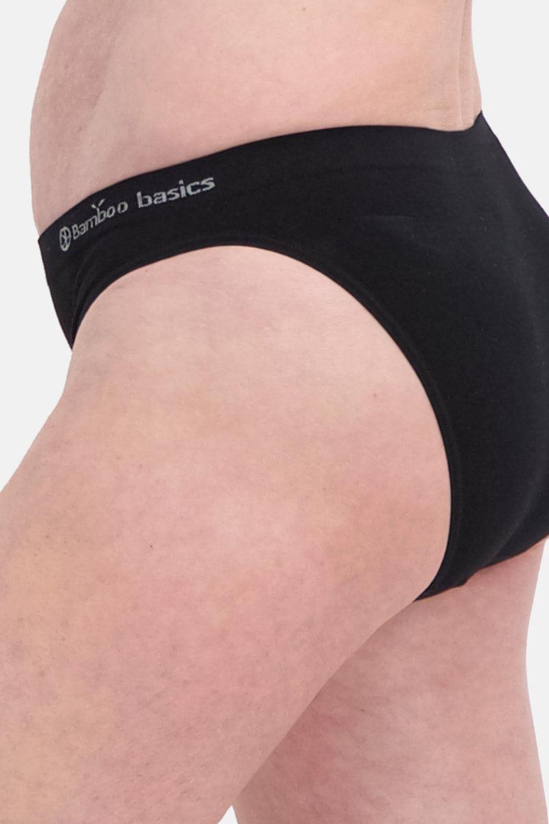 Side profile of a woman wearing black Bamboo Basics underwear against a plain background