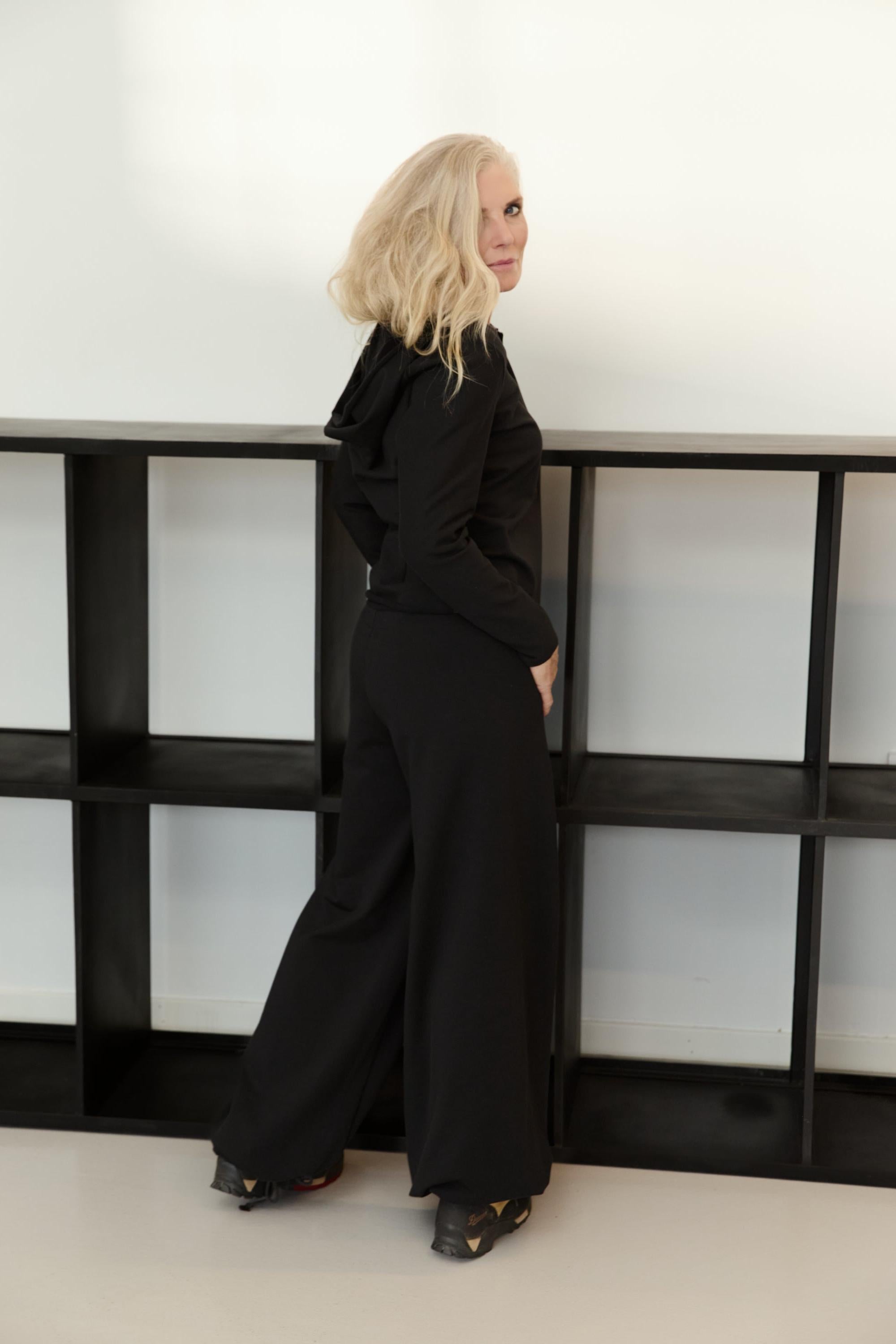 Woman wearing a black Henriette Steffensen organic cotton hoodie and matching trousers