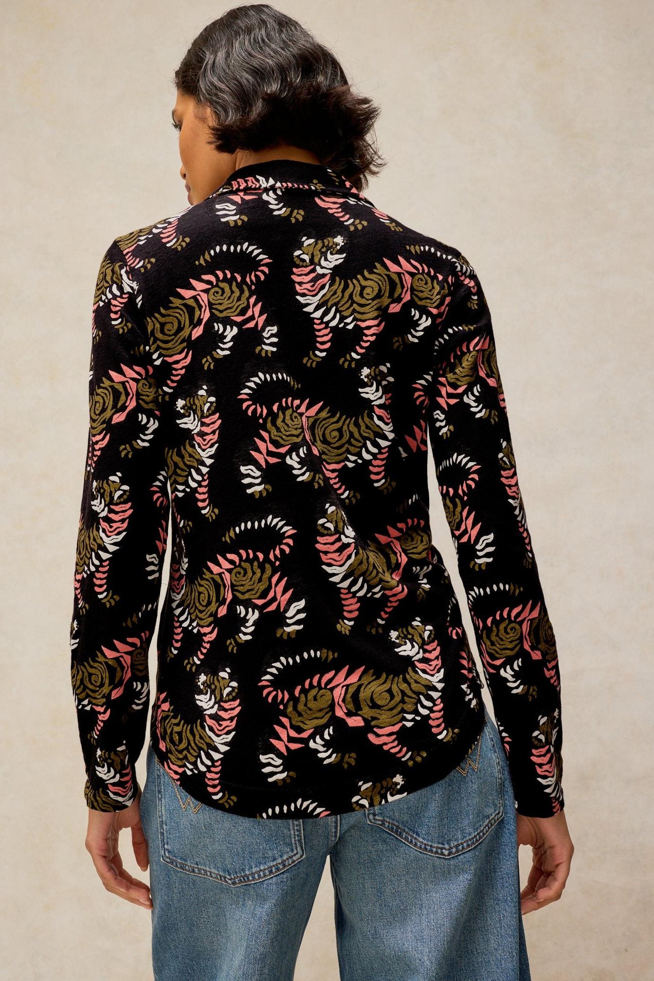 Rear view of a woman wearing a black long-sleeve cotton jersey shirt with a tiger print pattern.