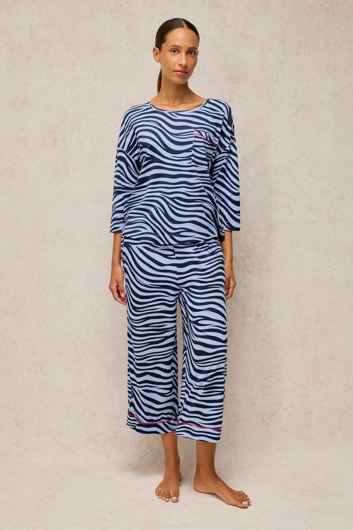 Woman standing in a blue animal print cotton blend pyjama set by White Stuff