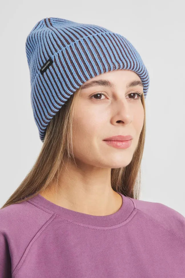 A woman wearing a ribbed blue cotton beanie hat from Dedicated Clothing.