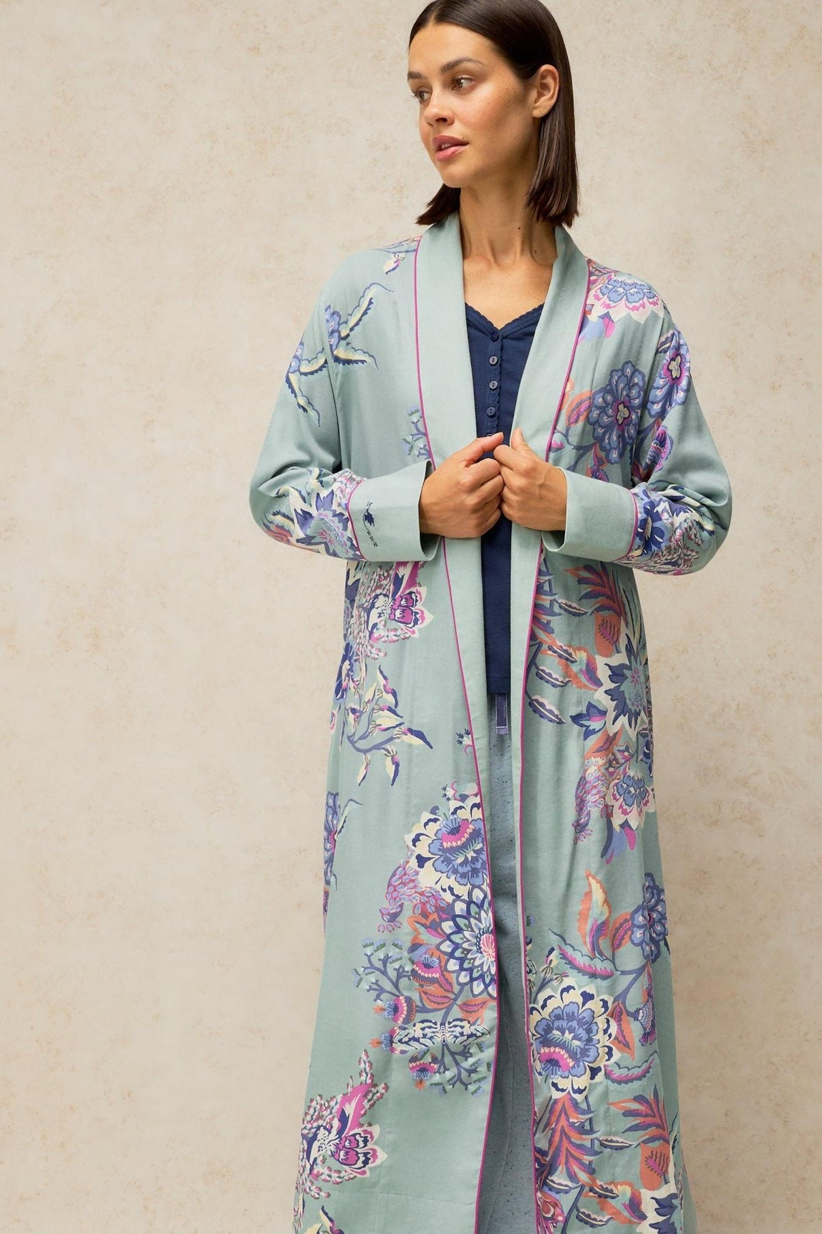 Woman modeling a blue floral pattern White Stuff dressing gown with pink trim