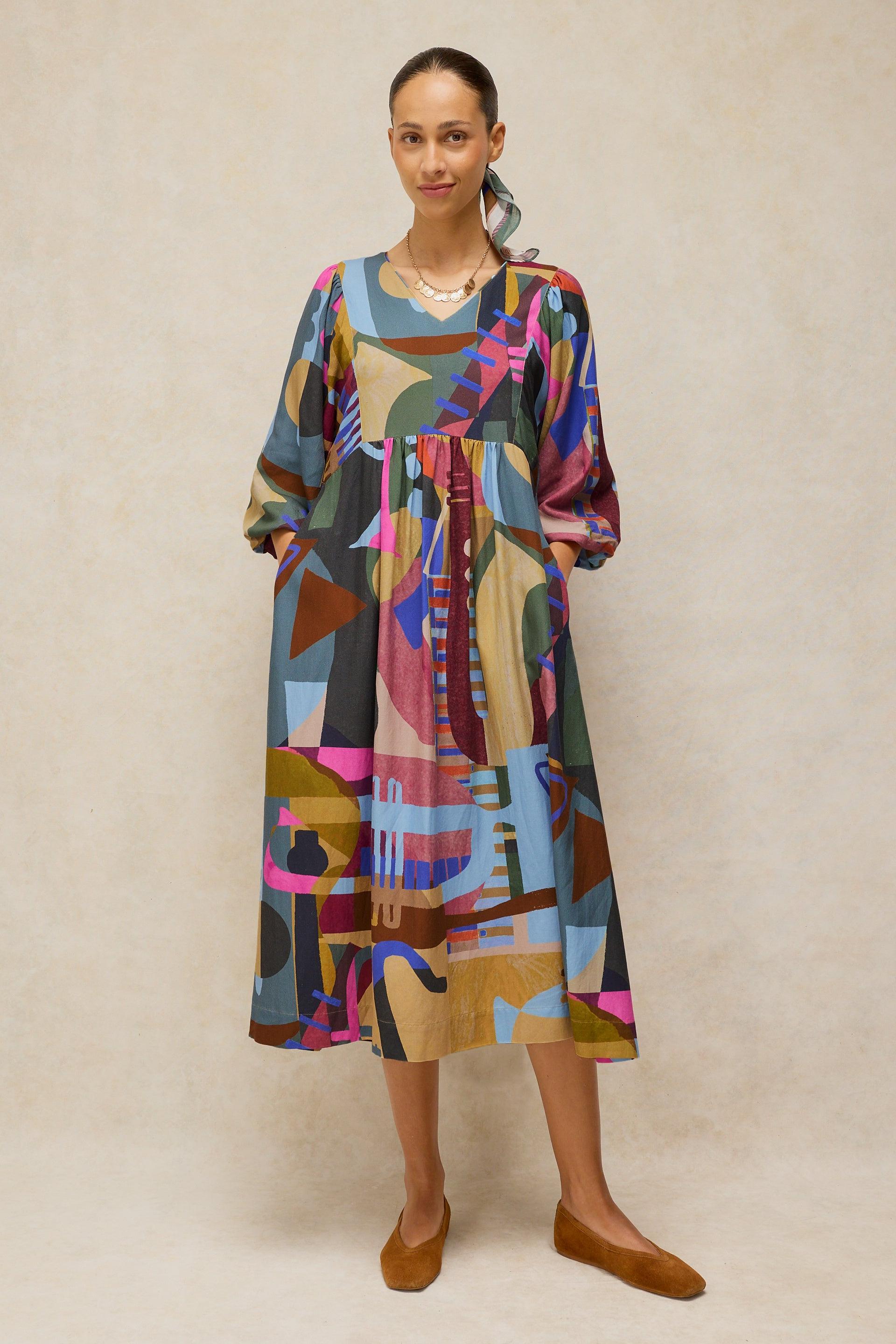 Woman wearing a colorful abstract print midi dress made from Ecovero fabric.