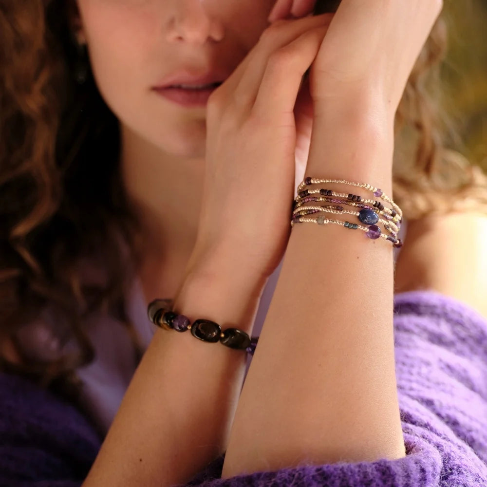 A woman wearing a delicate lapis lazuli gemstone bracelet on her wrist as a gift for her.