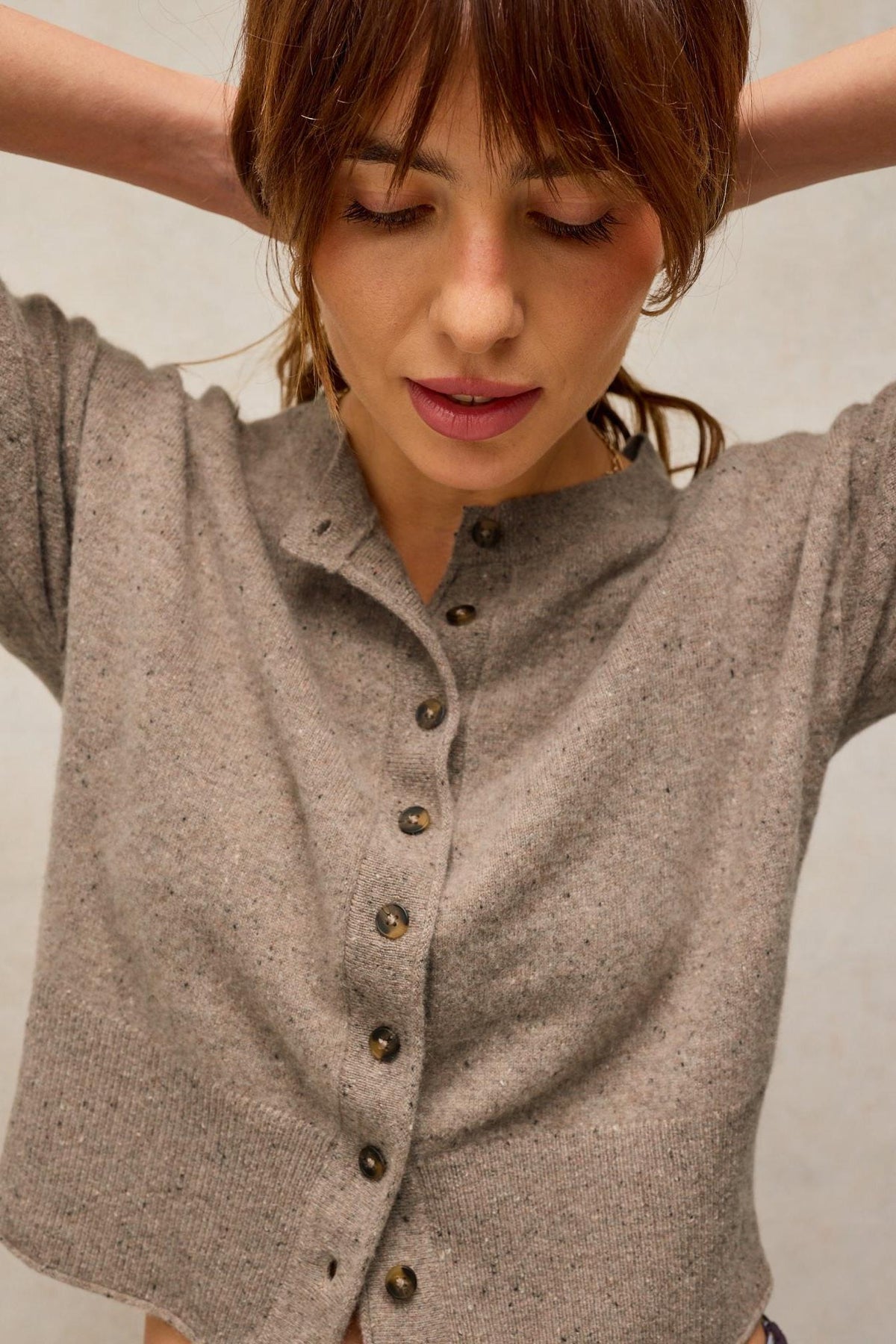 Woman wearing a button-down natural colour cashmere knit cardigan