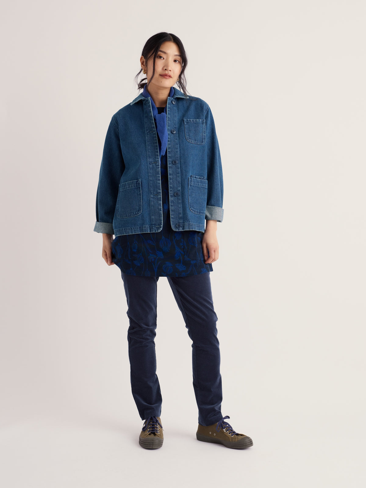 Woman modelling Seasalt Cornwall outfit featuring navy organic cotton cord trousers and a blue denim jacket.