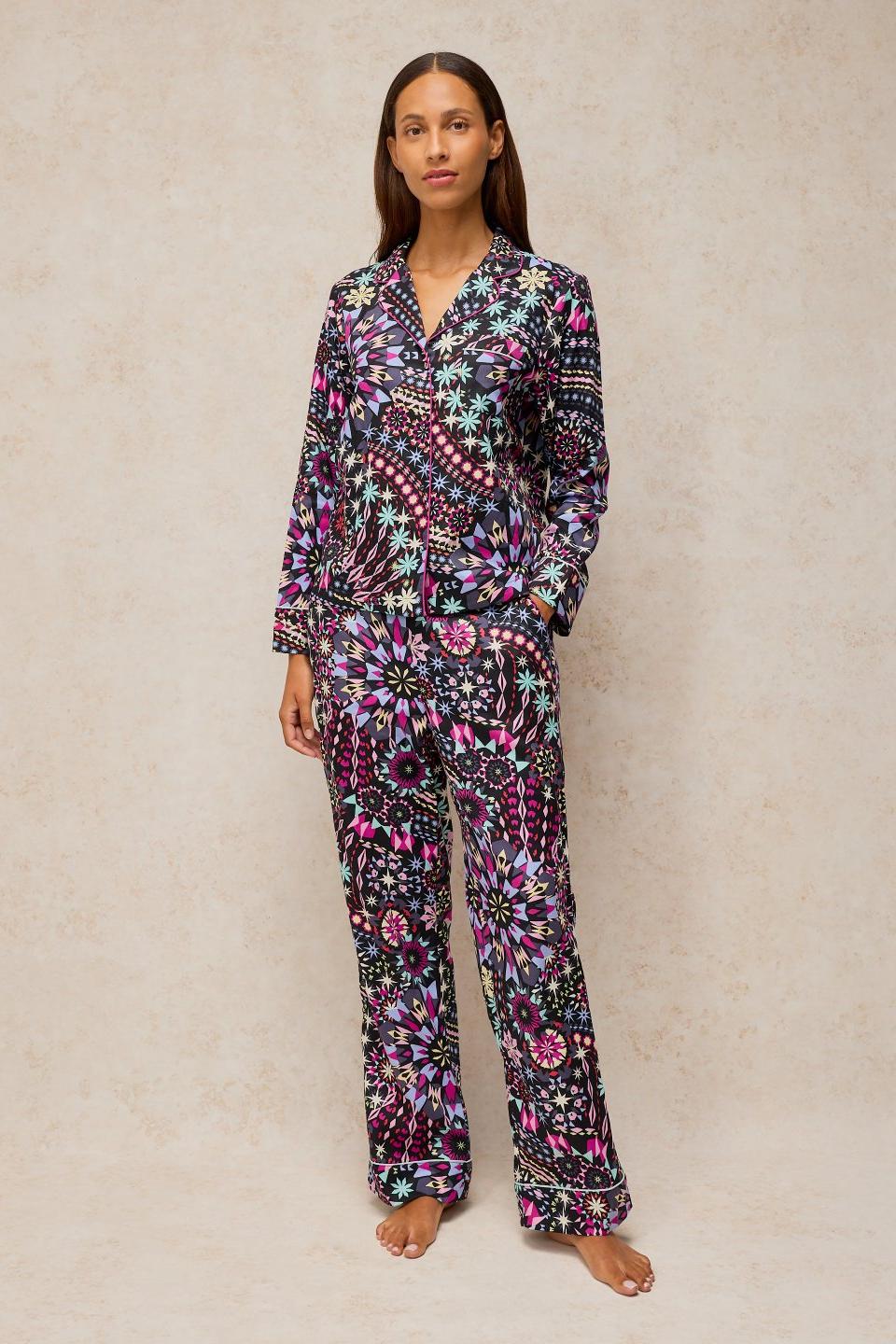 A woman posing in White Stuff organic cotton pyjamas with a black geometric print.