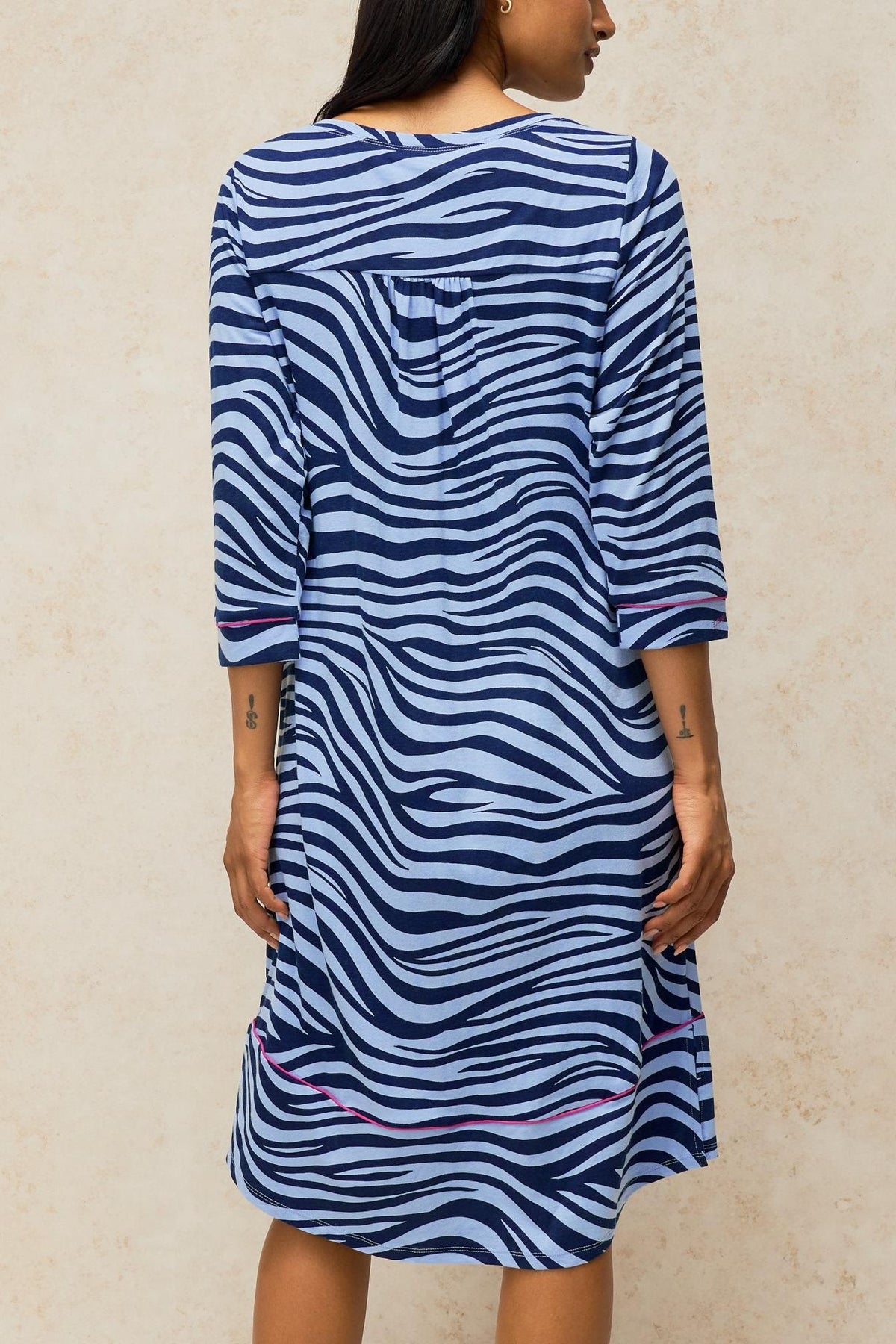 Woman standing from behind wearing a blue zebra print organic cotton nightdress