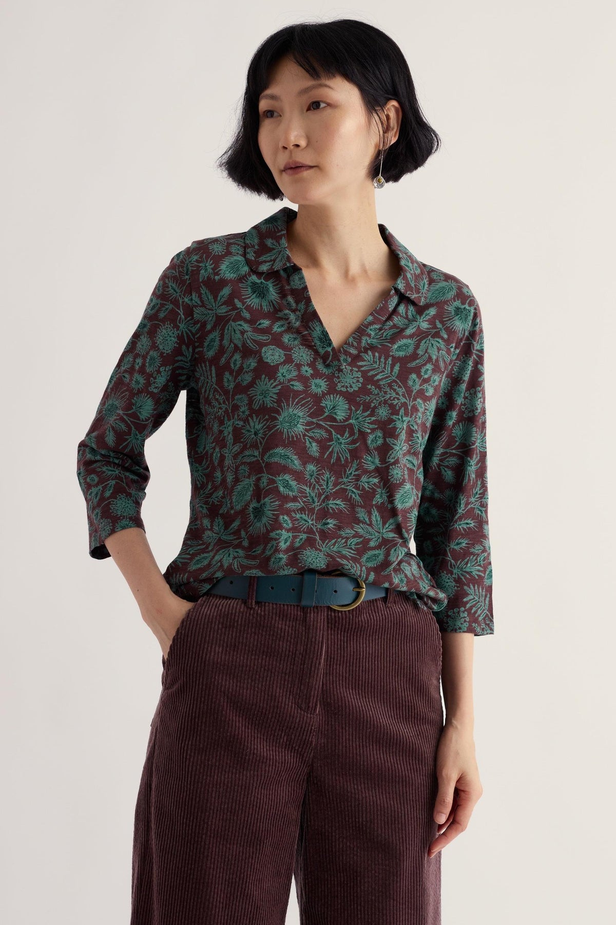 A woman wearing a brown and blue floral print organic cotton long sleeve shirt by Seasalt Cornwall.