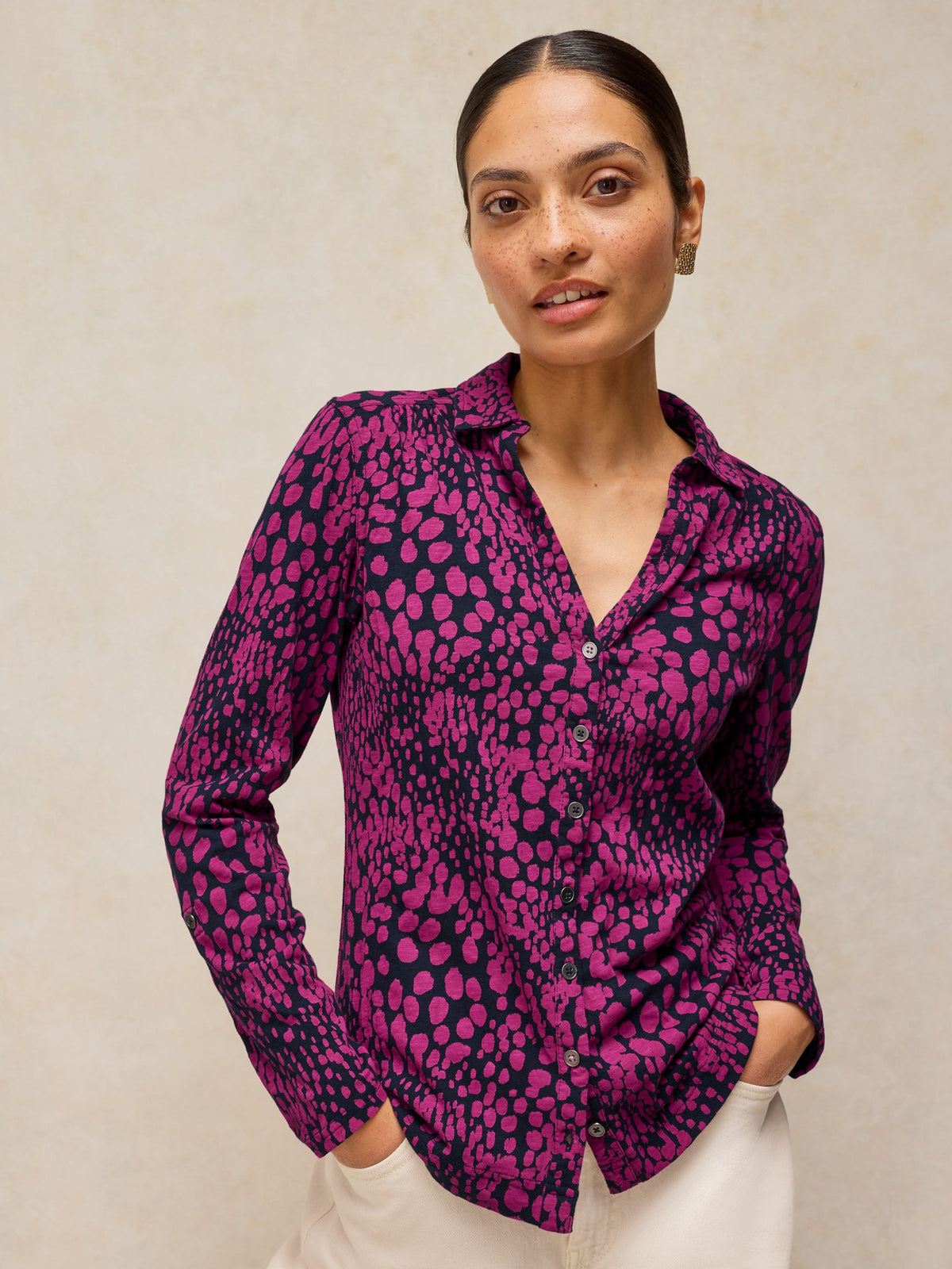 Woman modelling a long-sleeve blouse with a pink animal print pattern against a neutral background.