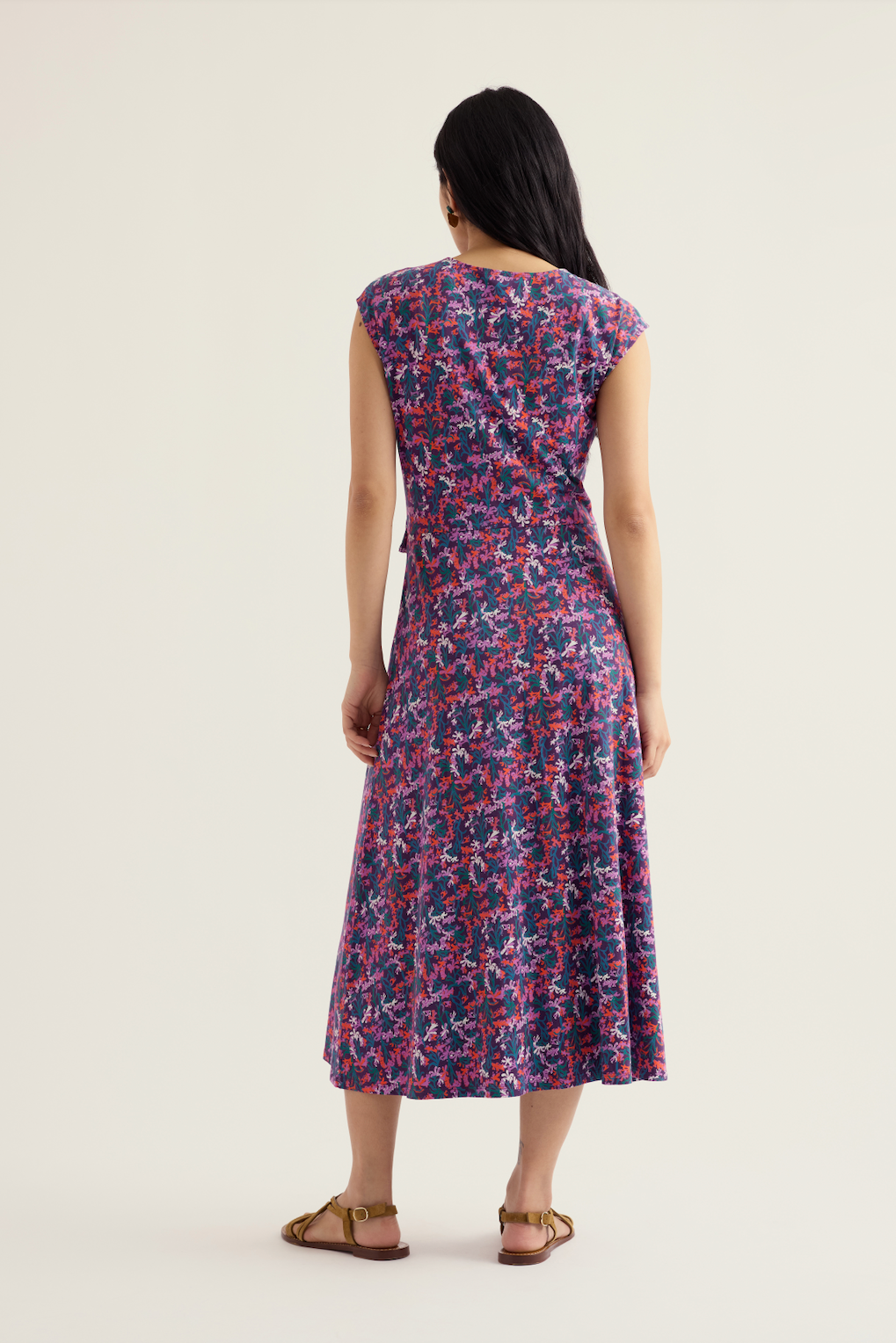 Back view of a woman wearing a Seasalt organic cotton floral print midi dress against a neutral background.