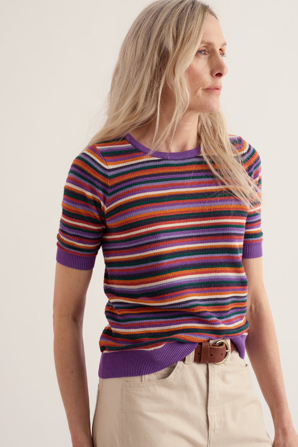Woman wearing a multi-colored striped organic cotton Seasalt top.