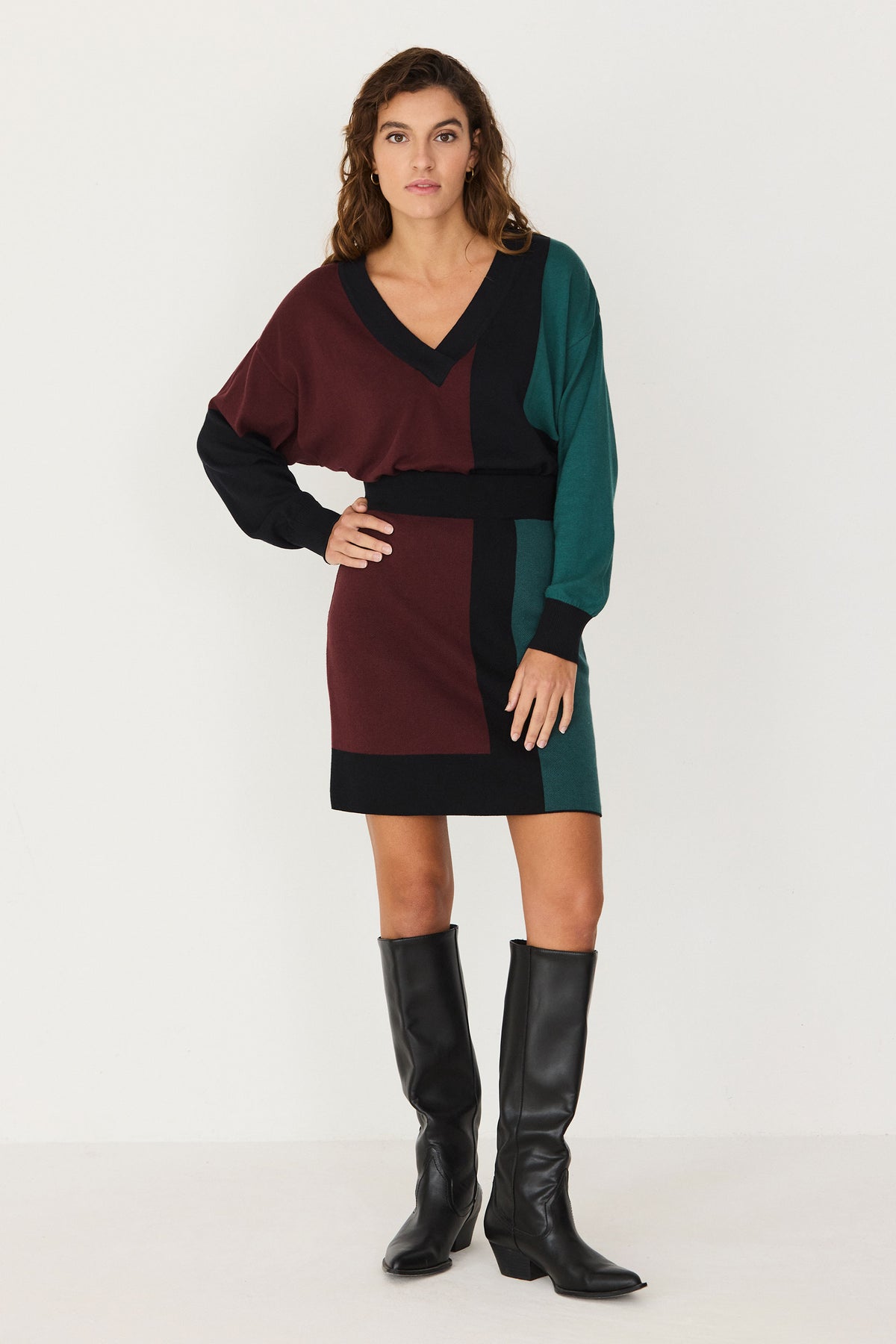 Woman wearing a SKFK colorblock winter skirt outfit with black knee-high boots.