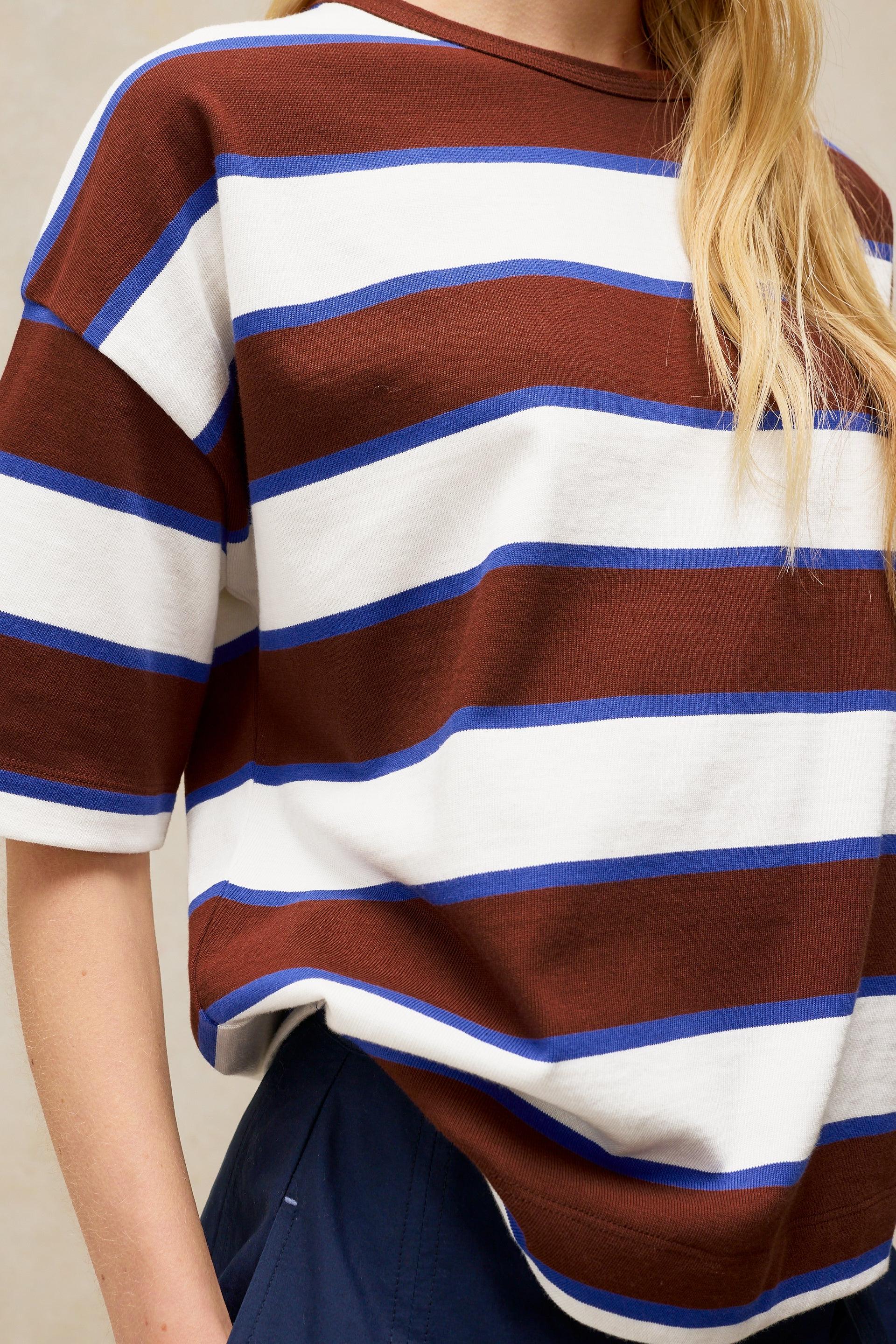 Woman wearing a brown, blue, and white striped organic cotton t-shirt