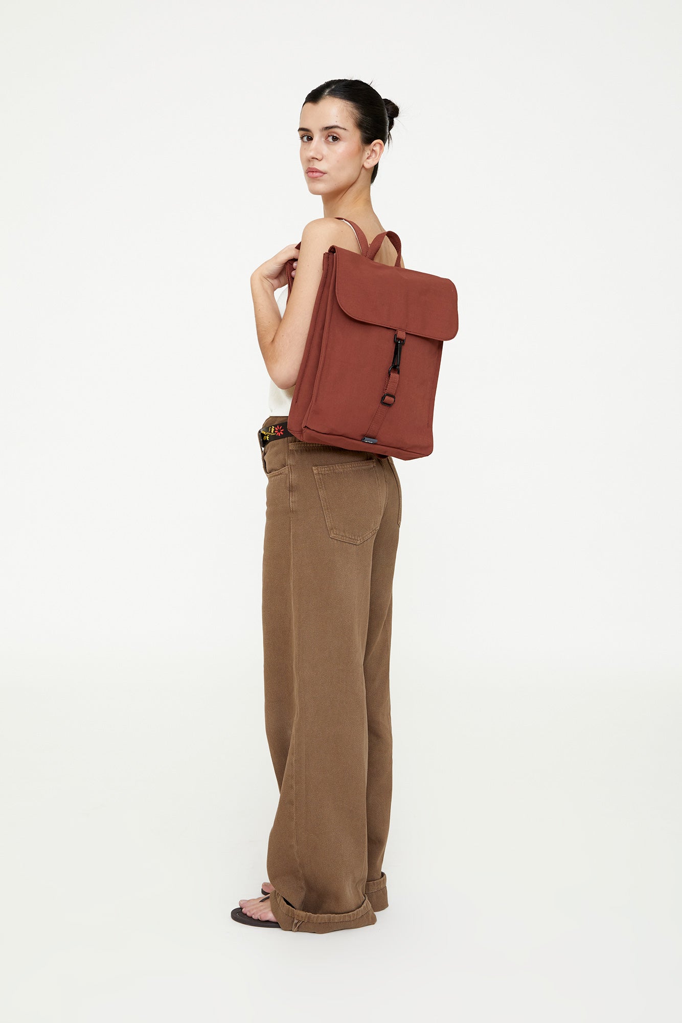 Woman holding a red backpack against a white background