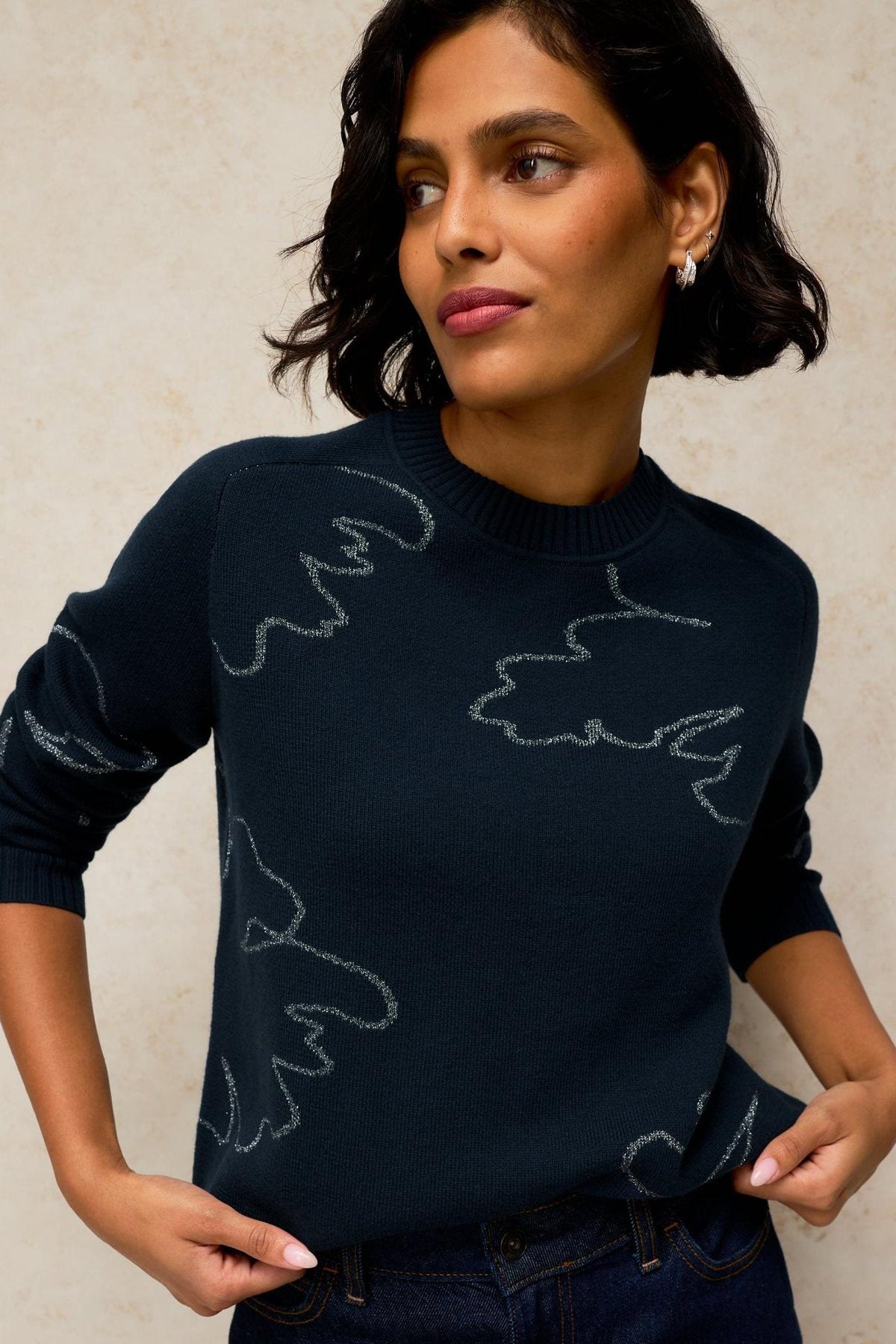 A woman wearing a White Stuff black jumper with sparkly abstract patterns