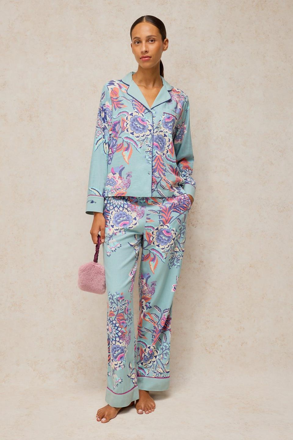 Woman standing in organic cotton blue print pyjamas from White Stuff, perfect for cosy gifts.