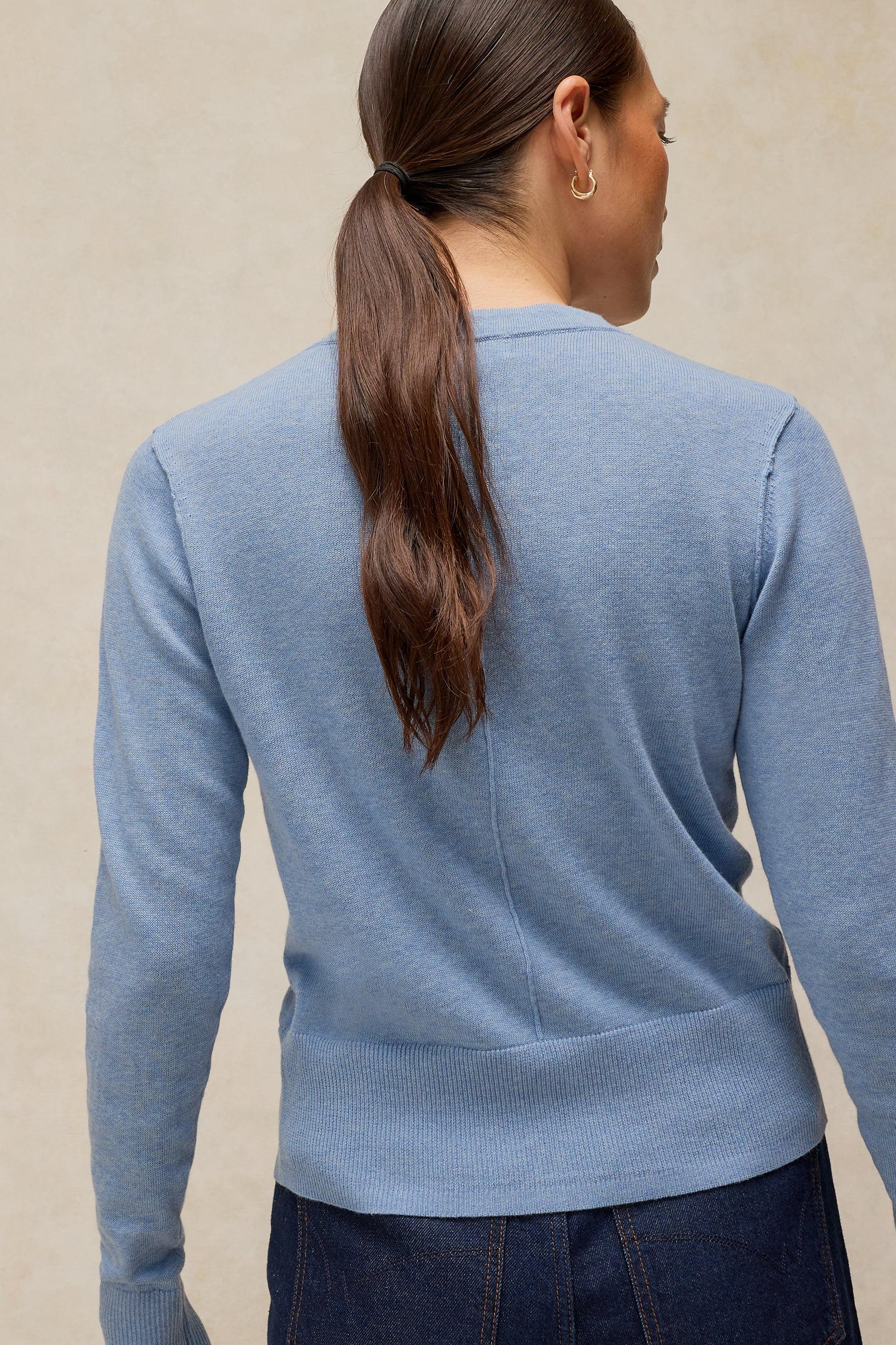 Woman seen from behind wearing a light blue White Stuff organic cotton sweater