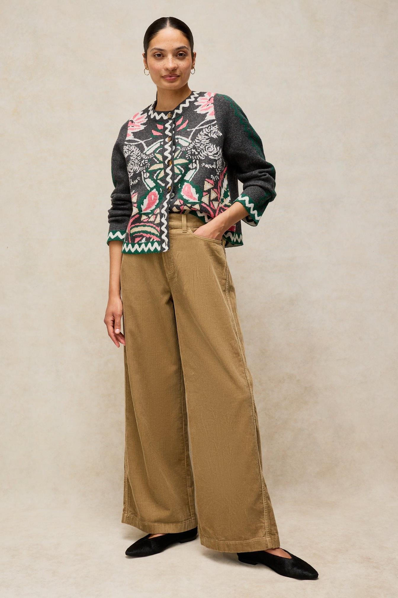 Woman modeling White Stuff tan wide-leg cord trousers with a patterned floral cardigan.