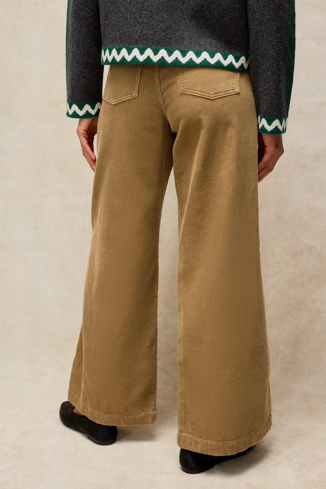 A rear view of a woman wearing tan organic cotton cord trousers from White Stuff.