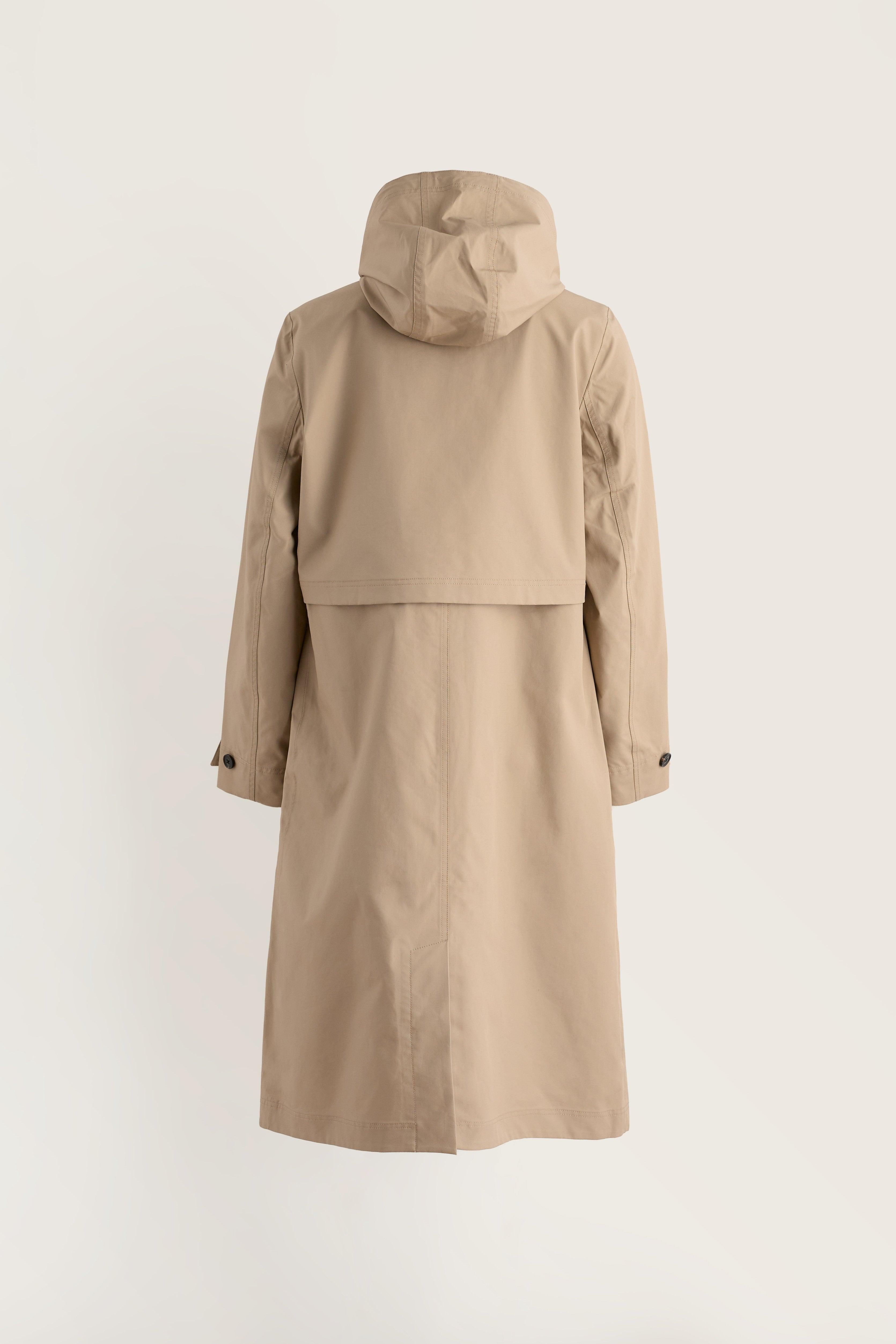 Rear view of a beige waterproof women's trench coat from Seasalt Cornwall on a light background.