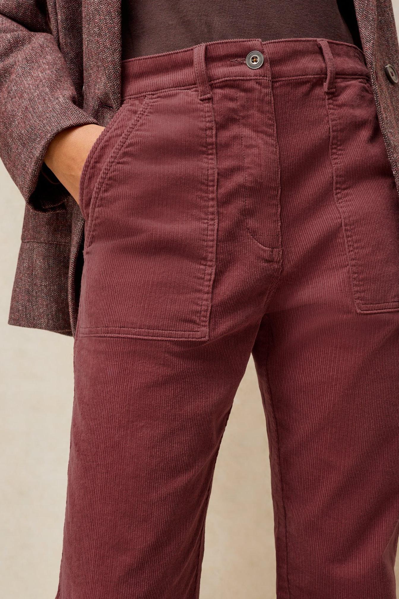 Close-up of women's pink corduroy trousers worn with a matching textured blazer for autumnal style.