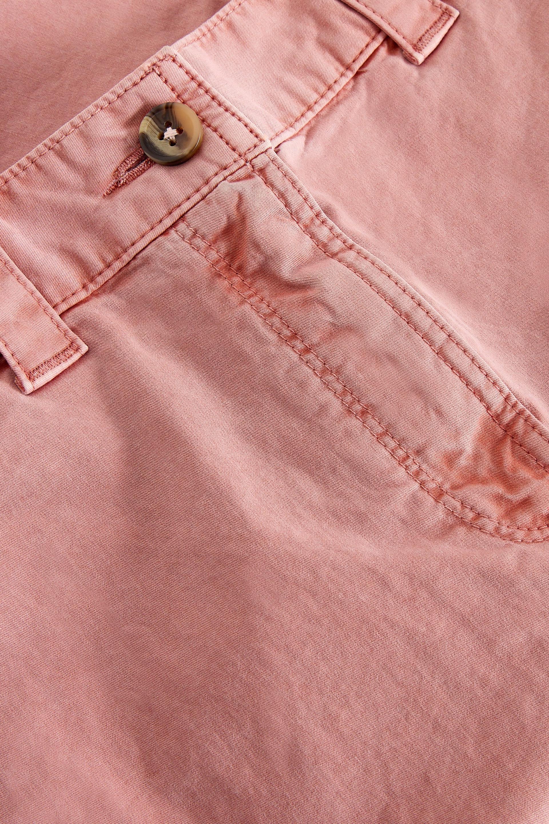 Close-up of pink organic cotton pants with a button and stitching detail
