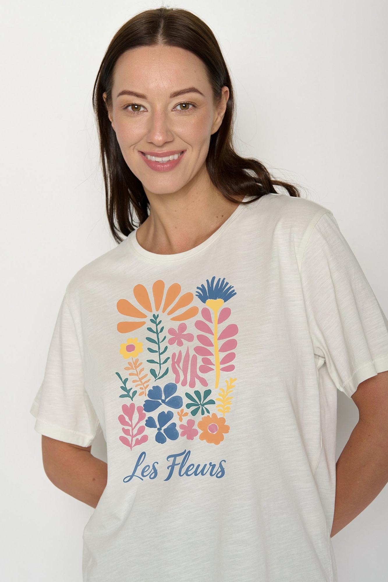 Woman wearing an organic cotton white t-shirt with colourful floral design and 'les fleurs' writing