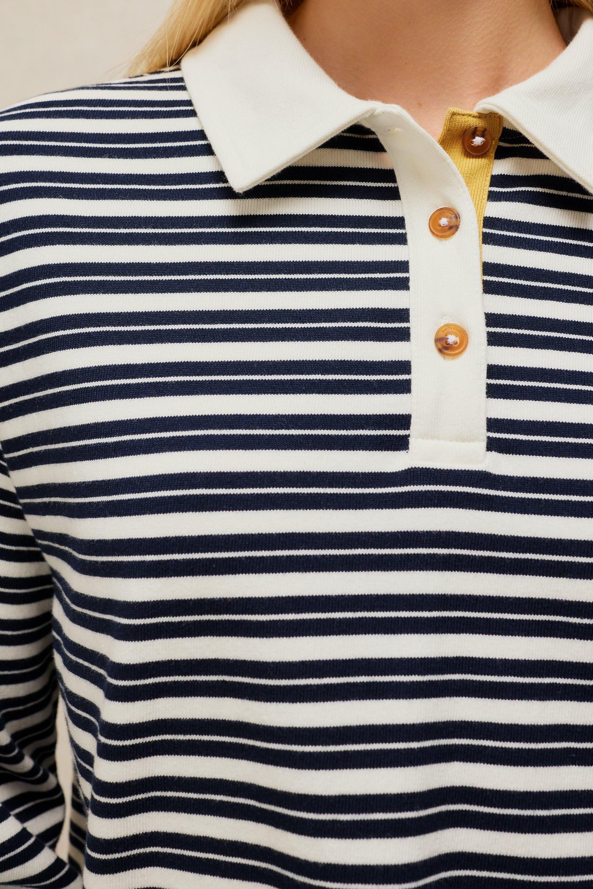 Woman wearing a navy and white striped long-sleeve organic cotton rugby top with a cream collar.