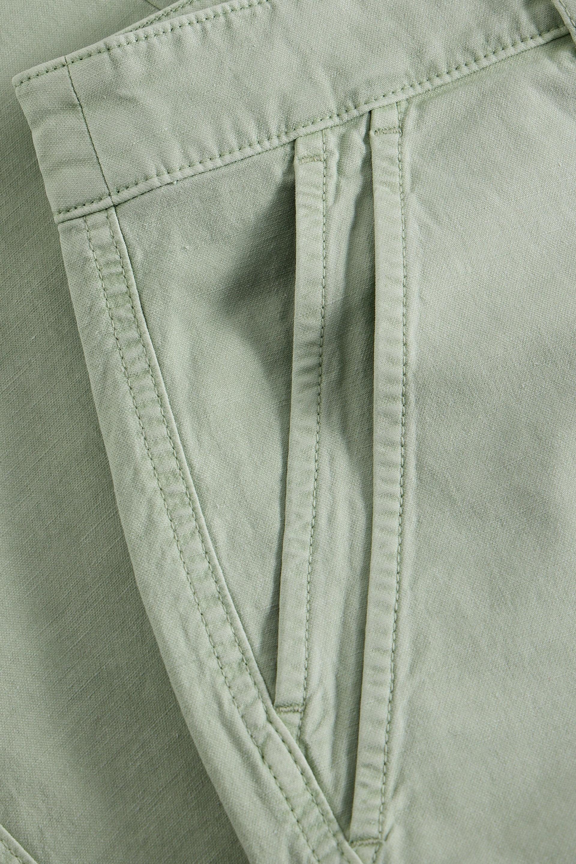 Close-up of light green pants with stitching detail
