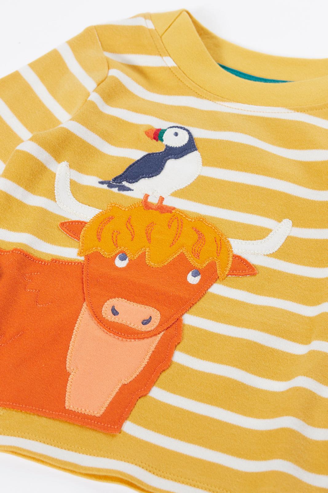 Yellow and white striped Frugi organic cotton top featuring an embroidered highland cow and a puffin.