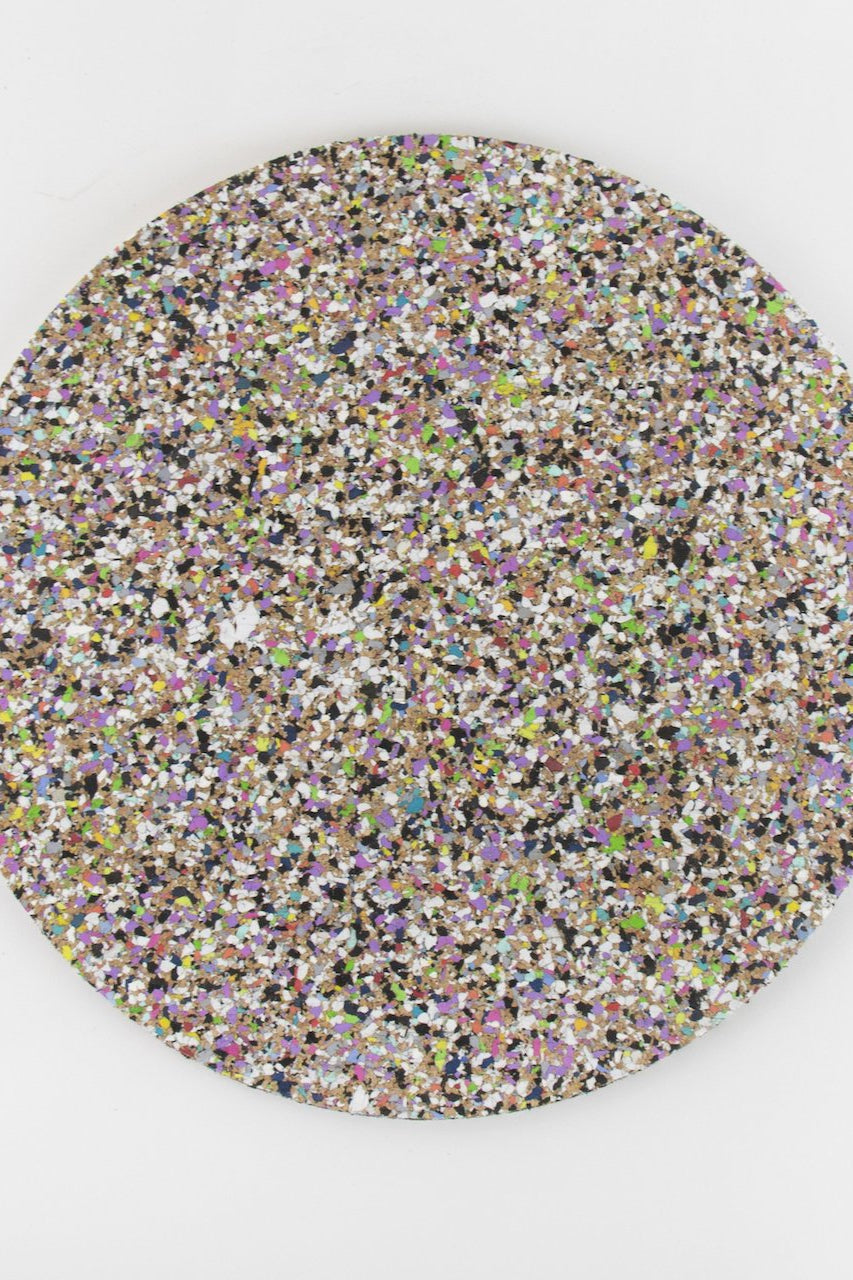 Detailed view of a Liga Beach Clean Round Placemat, highlighting the distinctive designs created from recycled materials.