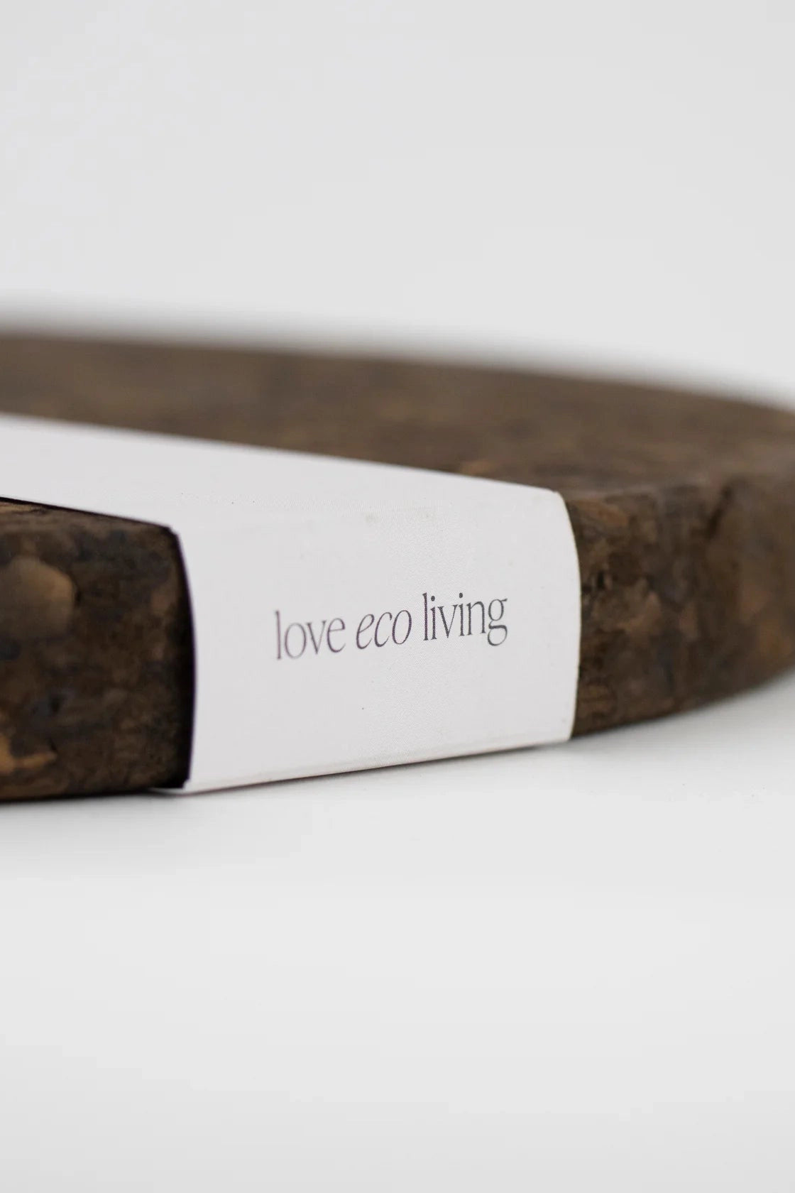 Close-up of the Liga Smoked Cork Trivet packaging with love eco living writing on it.